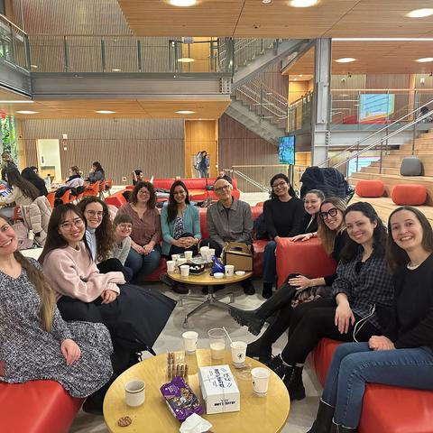 HSSPA members gathered in a circle, smiling at the camera. Coffee and cookies are on the tables.